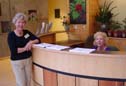 Dee Welker and Jane Avinger welcome visitors at the reception desk. 