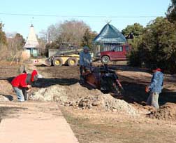 Tim Ketchie, Kim Powell, and Bradley Holland (left to right) improve drainage near the Perennial Border extension.